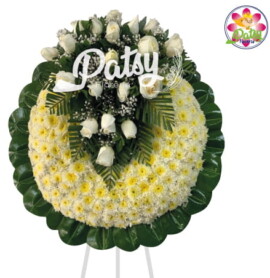 Hermosa corona fúnebre de pompos blanco con bordes verde de hojas de caucho verde con un arreglo floral en forma de V con rosas blancas y Gibson